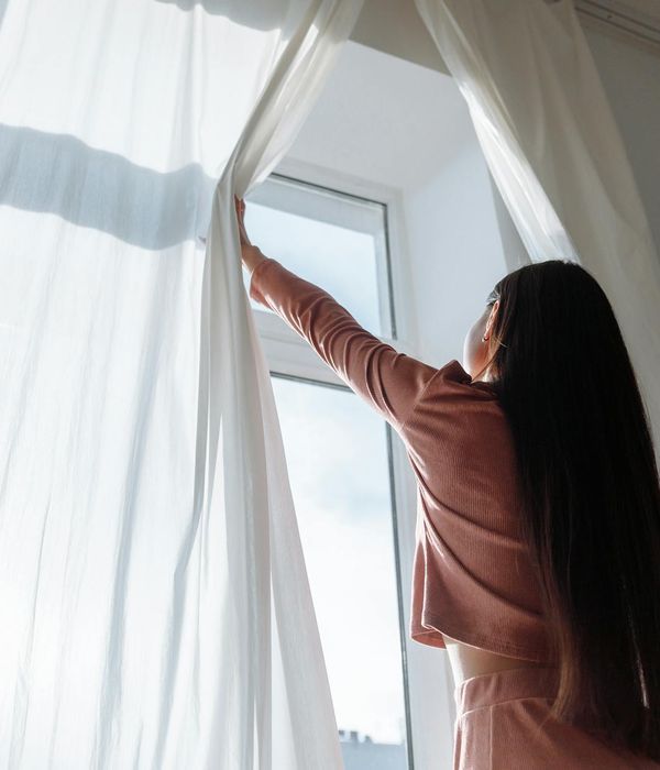 Woman feeling refreshed and energetic in a bright, airy room.